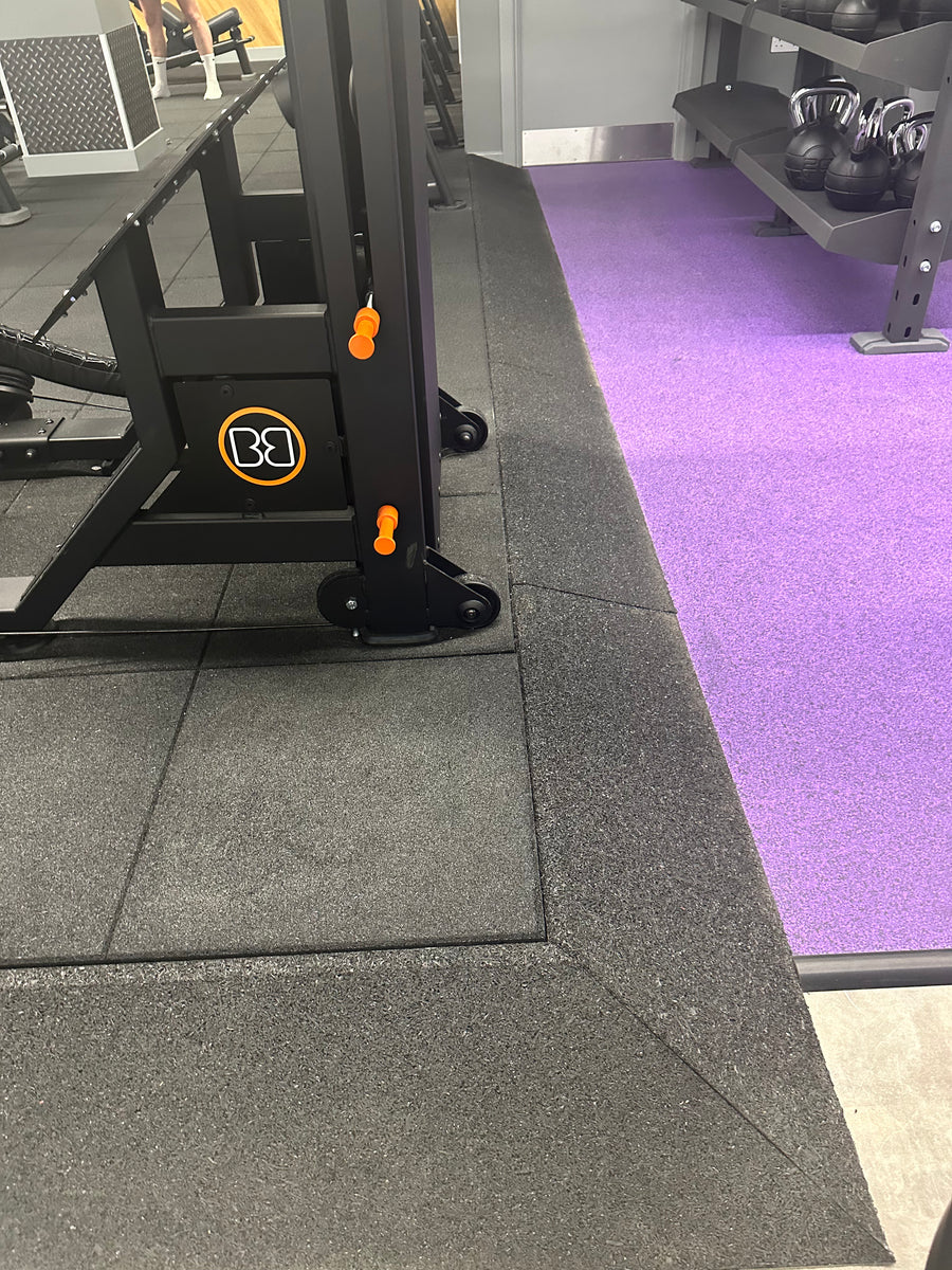 SilentTile 30mm Acoustic Gym Flooring Fitness Interlocking Tile; black rubber tiles in gym, slightly lifted corner, offering soundproof and vibration damping properties. Ideal for noise reduction in high-traffic fitness areas.