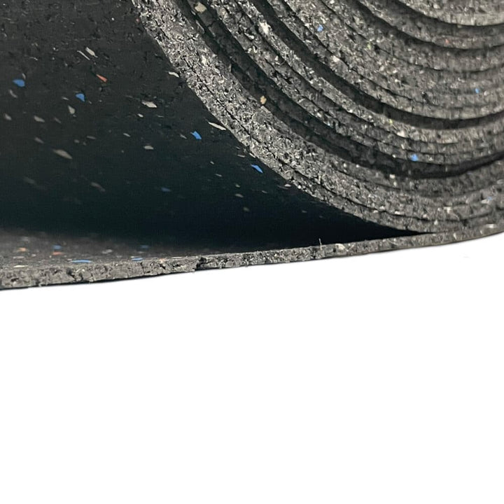 Close-up of rolled recycled rubber soundproofing underlay with speckles, showing inner layers and textured surface