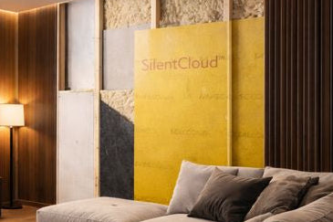 SilentCloud ProMass 50 self-adhesive acoustic membrane (2.6 mm, 5 kg/m²) installed behind wall panels in a modern bedroom, demonstrating high-density soundproofing.