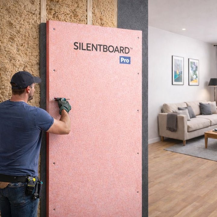 Man installs Professional 27 mm Direct-to-Wall Soundproofing Panel for Stud Walls – Part E Capable using a drill, enhancing sound insulation and vibration damping in a home renovation setting.